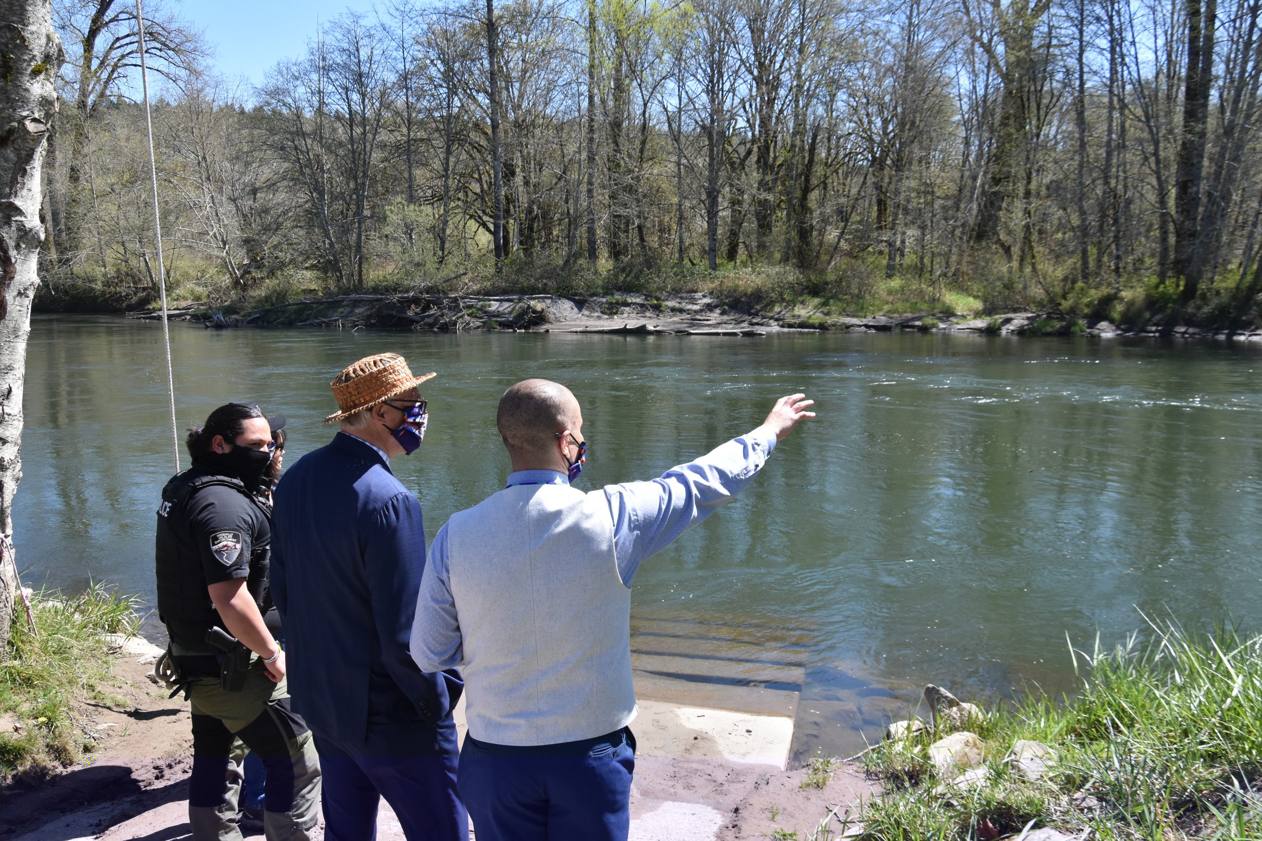 Gov. Jay Inslee looks over a river near the Wa He Lut Indian School in April 2021.