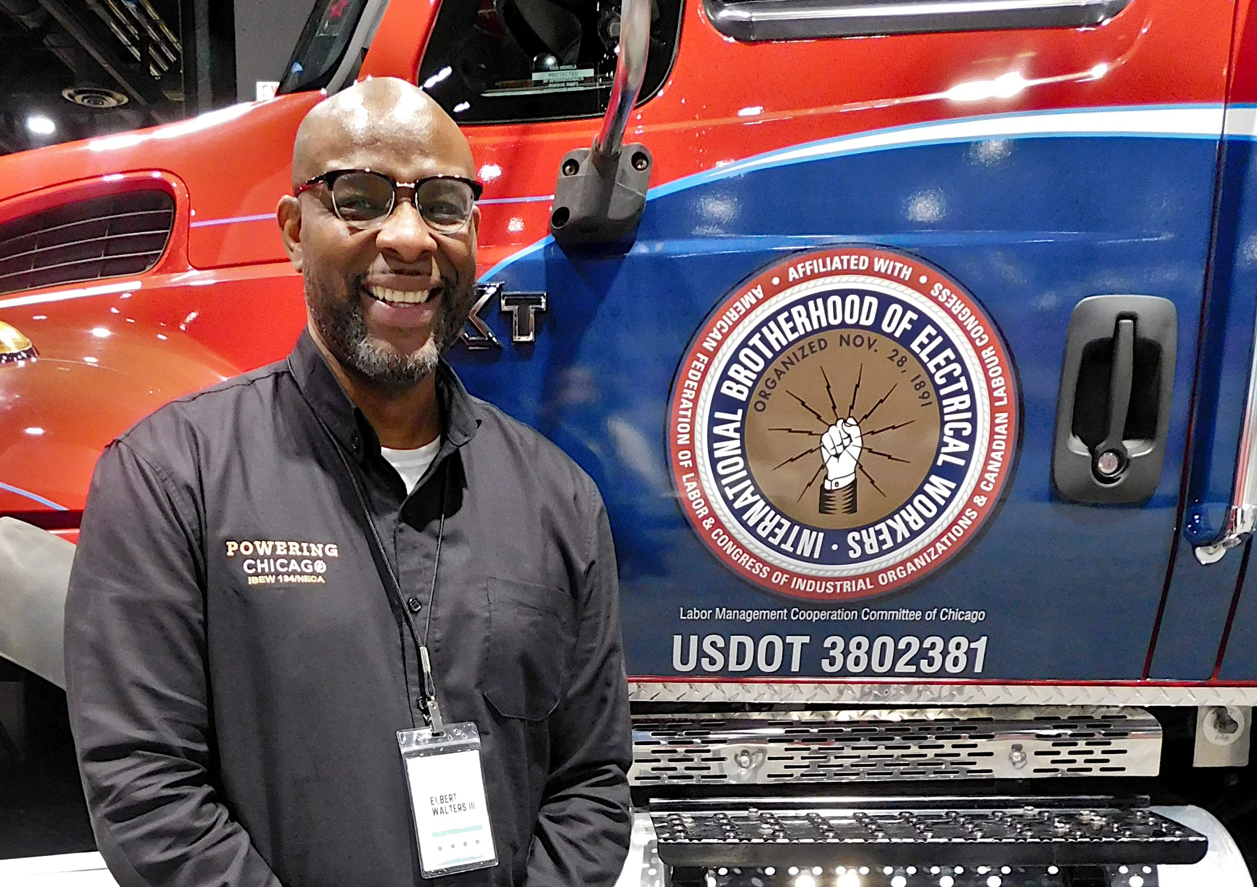 Elbert Walters III, executive director of Powering Chicago, poses with a mobile training lab at the 2023 Chicago Auto Show.
