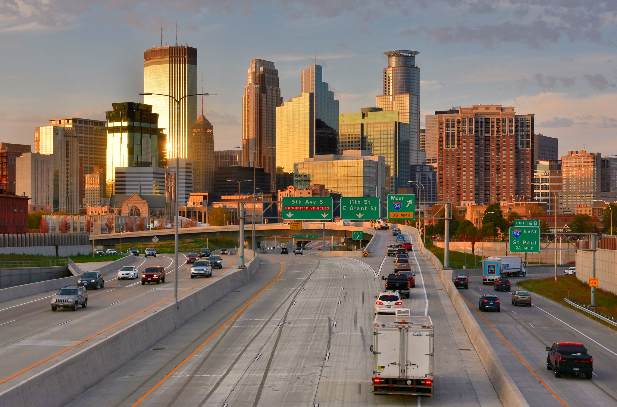 A massive width of highway approaches the downtown Minneapolis skyline